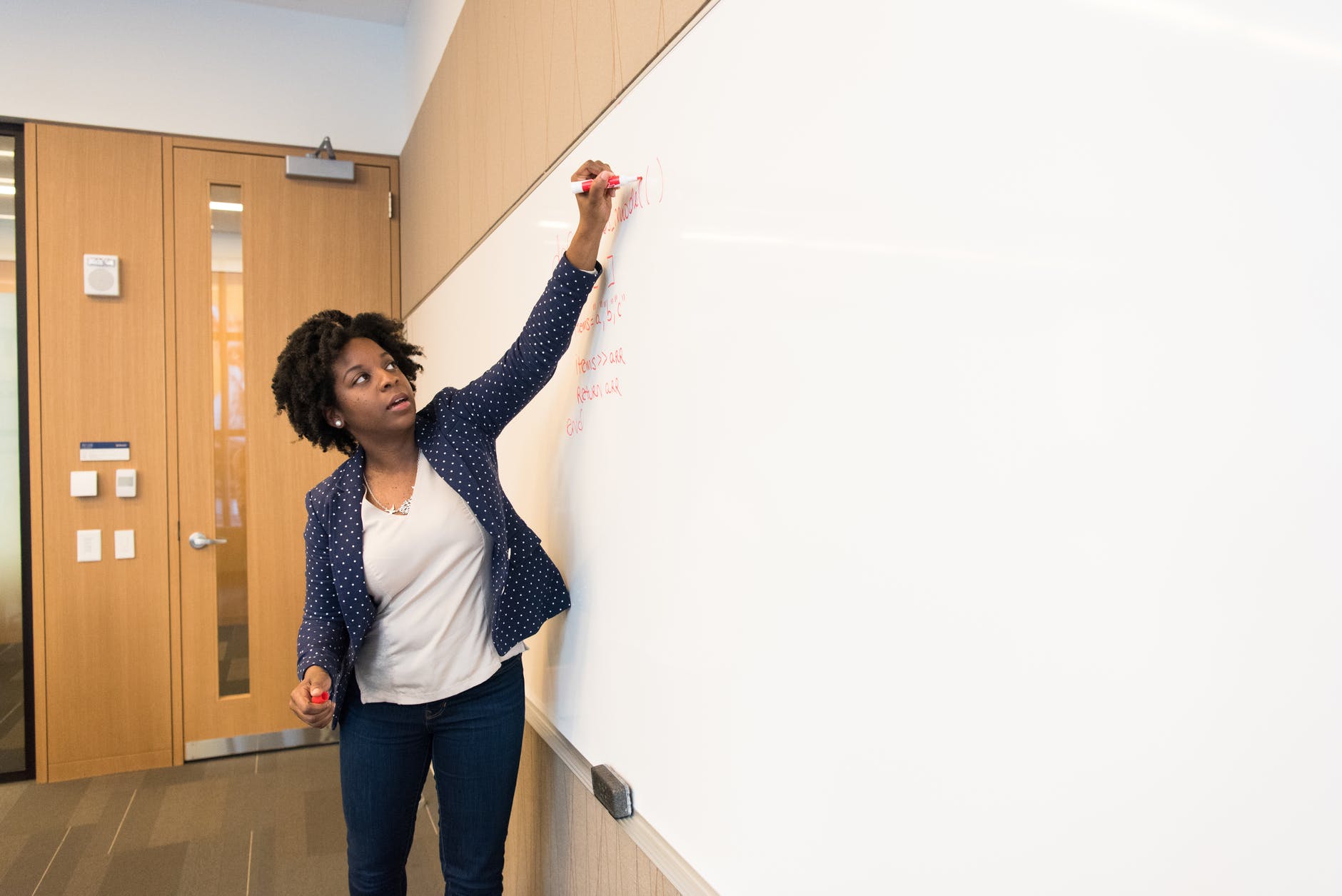 woman writing on dry erase board